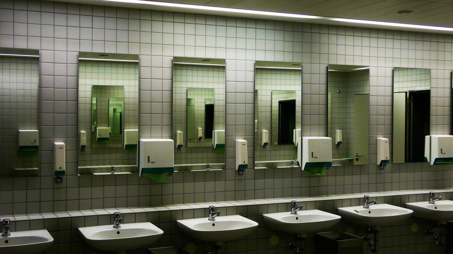 A restroom with mirrors and white ceramic sinks and faucets. Photo by Wilhelm Gunkel on Unsplash.