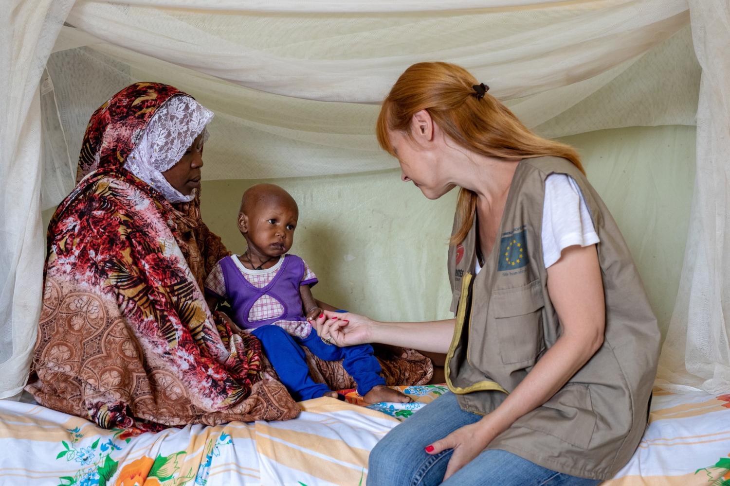 Aid Worker with young child and mother