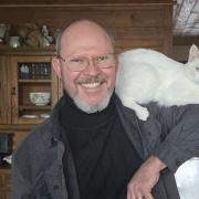 Professor Chris Beekman holding his pet cat on his shoulder