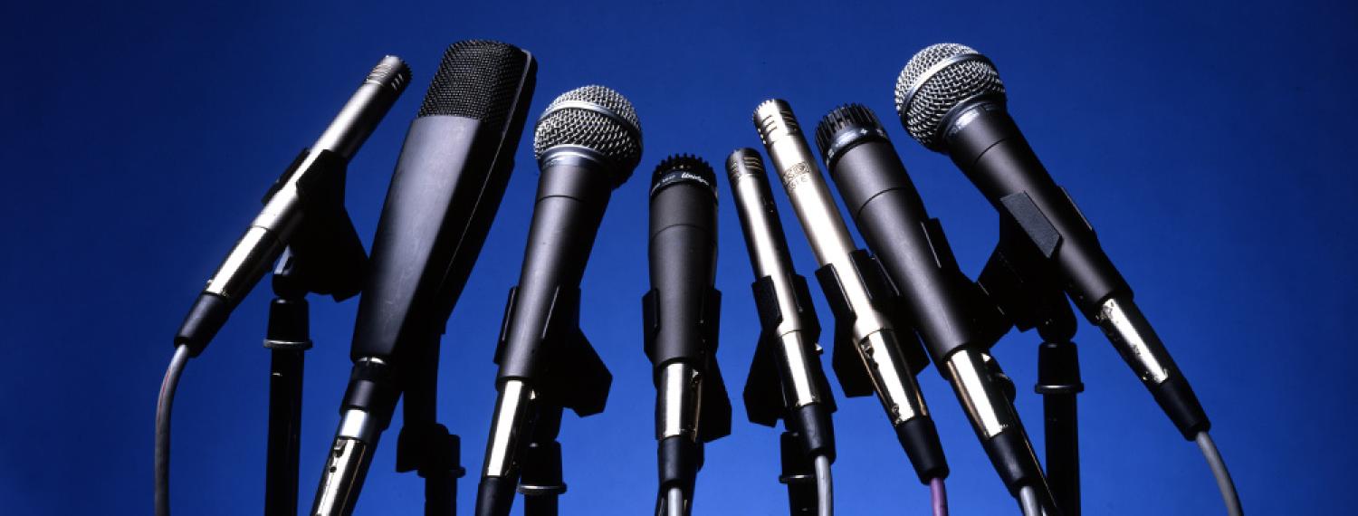 Group of microphones with no people behind them.