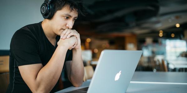 Man looking at laptop screen. Photo by <a href="https://unsplash.com/@sickhews?utm_content=creditCopyText&utm_medium=referral&utm_source=unsplash">Wes Hicks</a> on <a href="https://unsplash.com/photos/man-wearing-headphones-while-sitting-on-chair-in-front-of-macbook-4-EeTnaC1S4?utm_content=creditCopyText&utm_medium=referral&utm_source=unsplash">Unsplash</a>   