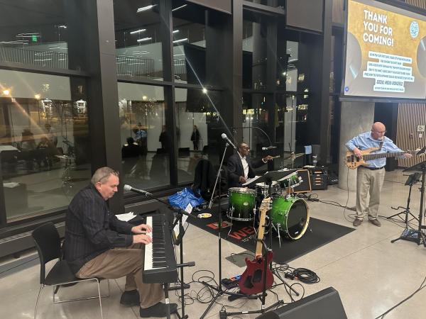Three musicians playing, a keyboard, guitar, and drums. 