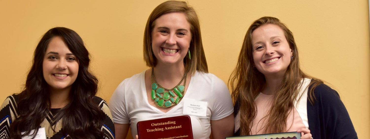 Photo of 3 students accepting RMCA awards. They are each posed with their awards and smiling.