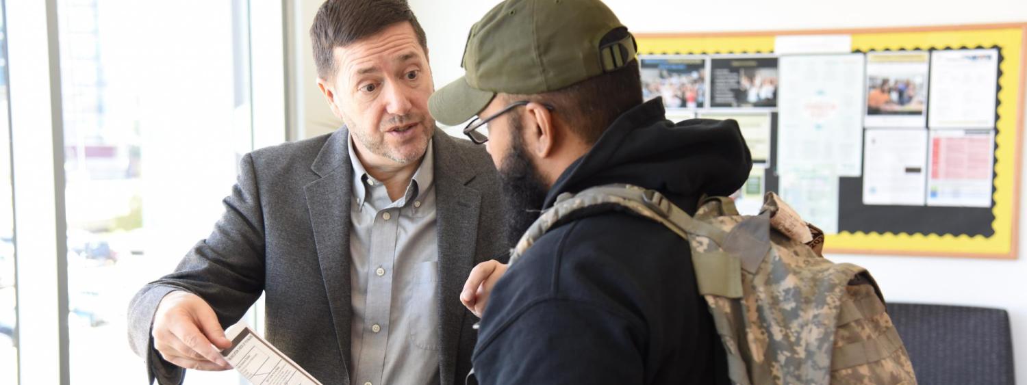 photo of Stephen Hartnett talking to a student
