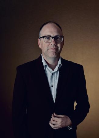 Dr. Thomas Dunn is a white mail wearing a suite and glasses