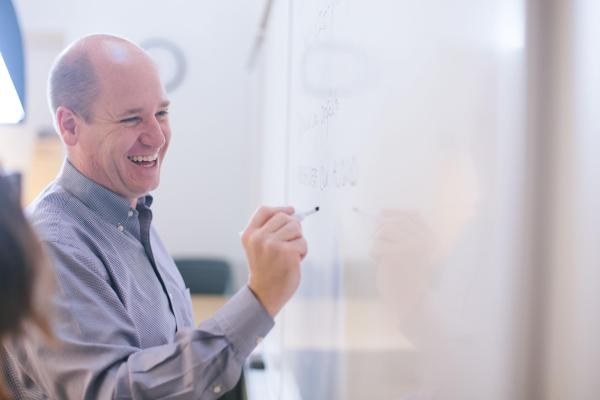 man writing on white board