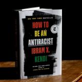 Ibram Kendi's book How to be an Antiracist standing up and partially open on a table.