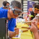 chemistry professor doing an experience while children look on