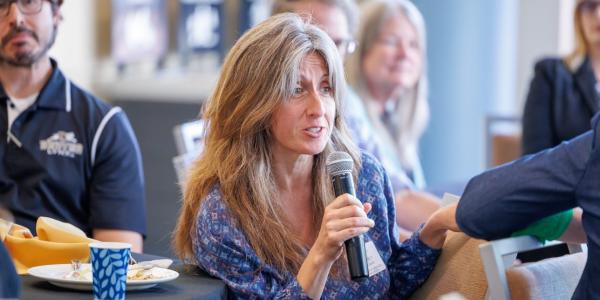 woman speaking into mic at event