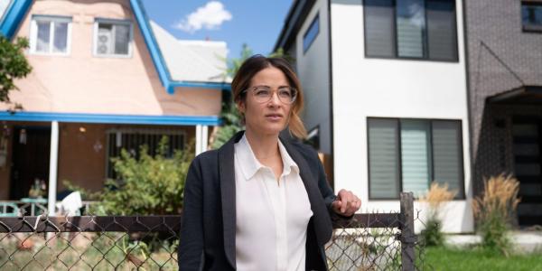 Dr. Esther Sullivan stands in front of homes