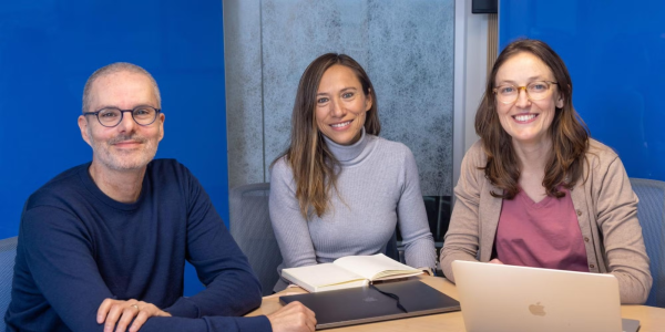 CU Denver Economics Professors Hani Mansour, Andrea Velasquez, and Chloe East sit at a table with laptop