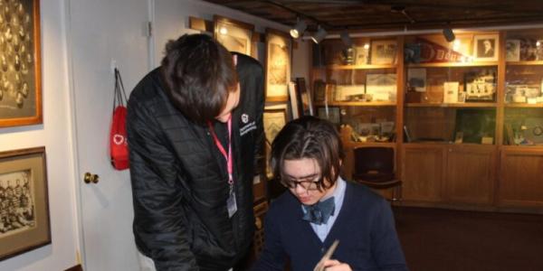 a teacher stands over a student at a desk
