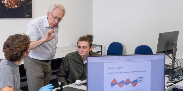 students working in a quantum lab with the professor