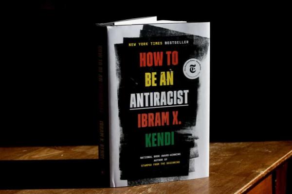 Ibram Kendi's book How to be an Antiracist standing up and partially open on a table.