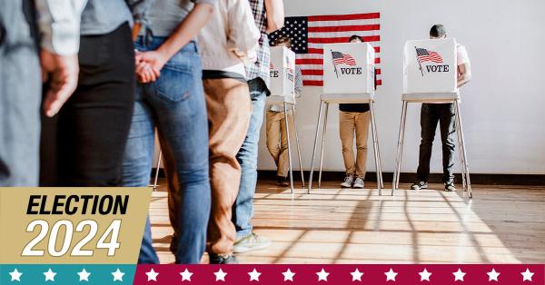 people standing in line to vote at a voting booth