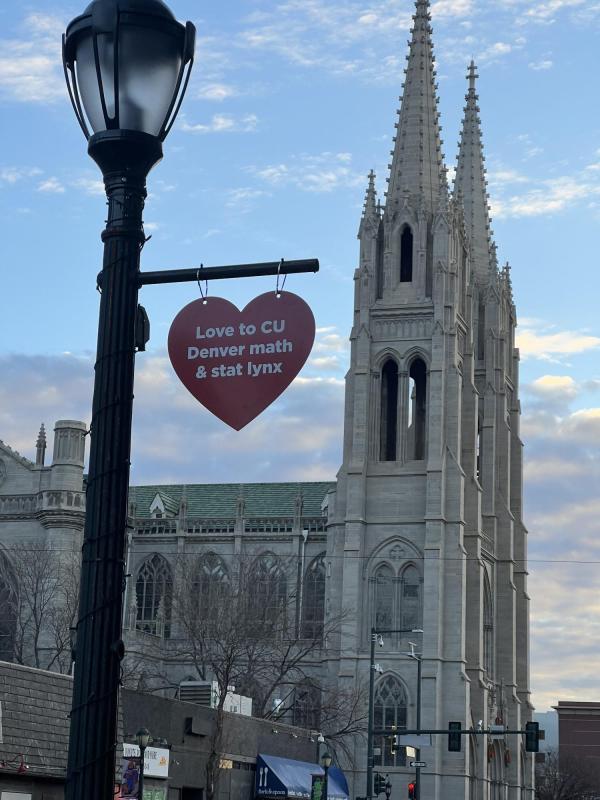 Heart shape hoisted on a lamppost saying Love to CU Denver math & stat lynx