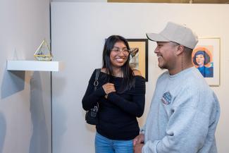 Vistors smile while looking at art