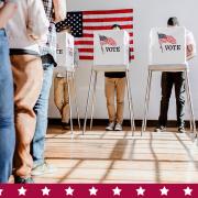 people standing in line to vote at a voting booth