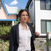 Dr. Esther Sullivan stands in front of homes