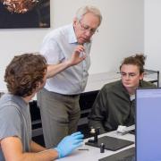 students working in a quantum lab with the professor