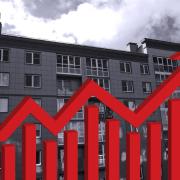 black and white apartment building with red arrow pointing up