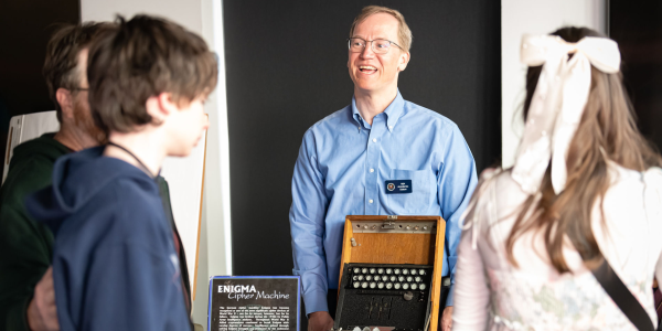 man with enigma machine at science fair
