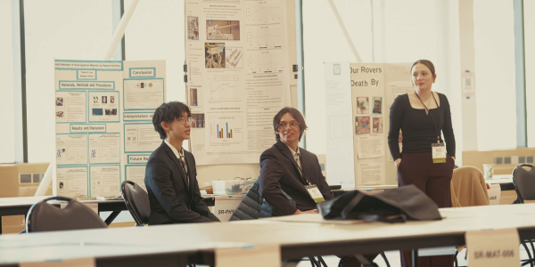 three students with science fair poster boards