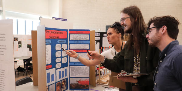 Judges evaluating science fair poster 