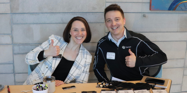 two volunteers at an event check in table