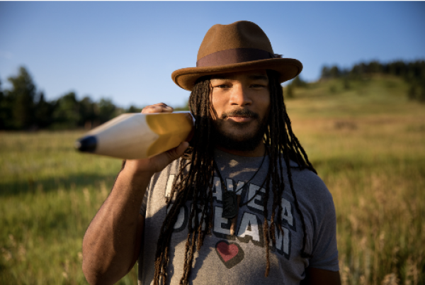 Jovan Mays carries a larger pencil in a field.