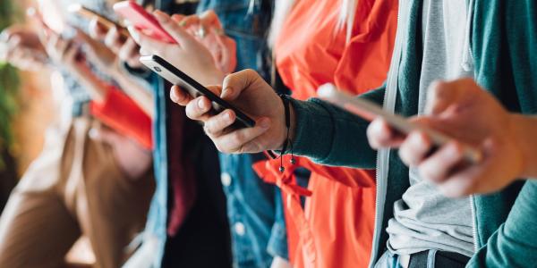 Example of a Decorative image - people holding cell phones while wainting in line.