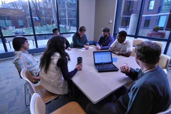 Students in a classroom around a laptop computer