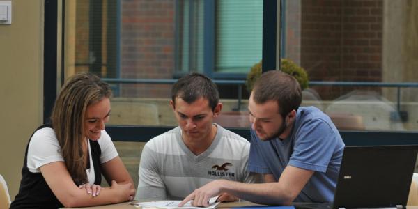 Three students looking over a document