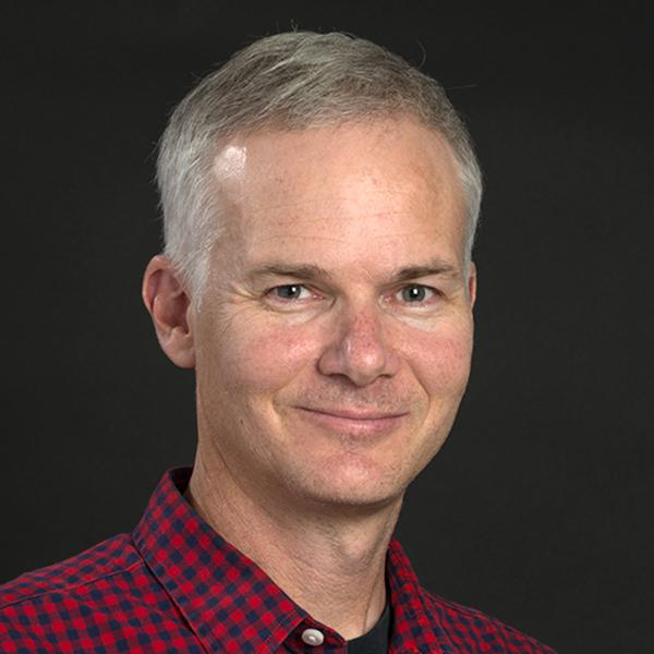 Grey-haired man in red checkered collared shirt