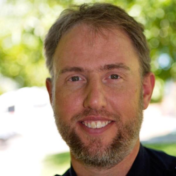 Brown-haired man smiling with beard