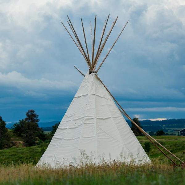 Tipi on a cloudy, prairie horizon.