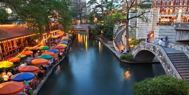 A photo of Riverwalk. Shops and restaurants line the river bank.