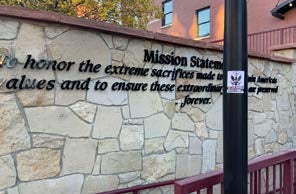 A sign belonging to the Center for American values against a brick wall. 