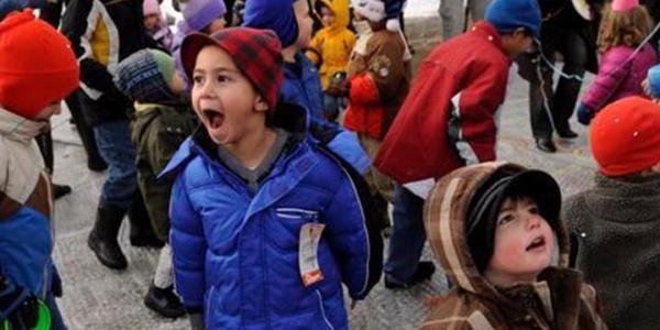 A group of young children and adults playing outside in the winter