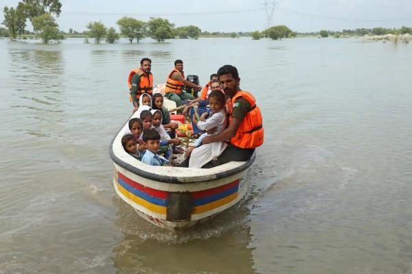 Rescue workers use a boat to drop children back at home after school in Dera Ghazi Khan district, Punjab province.