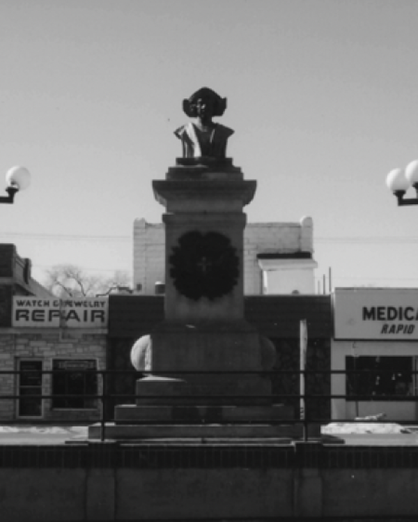 A stone bust monument of Columbus on a pedestal.