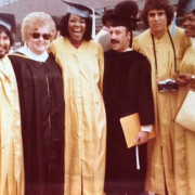 Mel Albaum, Ila Warner, and Population Dynamics students in gold caps and gowns, smiling at graduation.