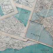Several vintage maps overlap, creating a visually textured surface. 