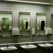 A restroom with mirrors and white ceramic sinks and faucets. Photo by Wilhelm Gunkel on Unsplash. 