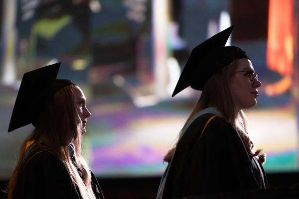 Two students in graduation regalia