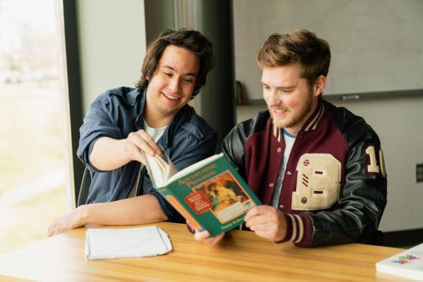 Students looking at a book in class. 