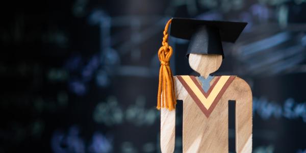 wooden figure with graduation cap
