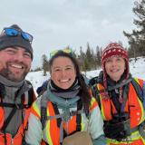 Researchers Vincent Spagnuolo, Karina Li, and Dr. Diana Tomback hiking through snowy Yellowstone National Park. 
