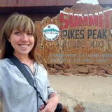 She took a selfie standing on top of Pikes Peak by the sign of elevation