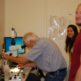 Ryan Jones wearing a red T-shirt in a lab smiling at the camera